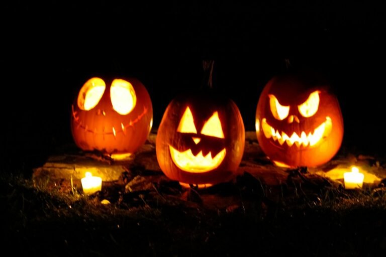Três abóboras de Halloween iluminadas à noite; fotografia ilustrativa