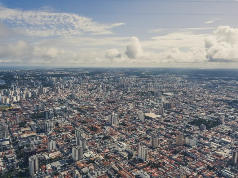 Vista aérea de edifícios e bairros de Aracaju sob céu com nuvens