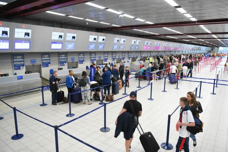 Passageiros aguardam atendimento nos balcões de check-in de um aeroporto