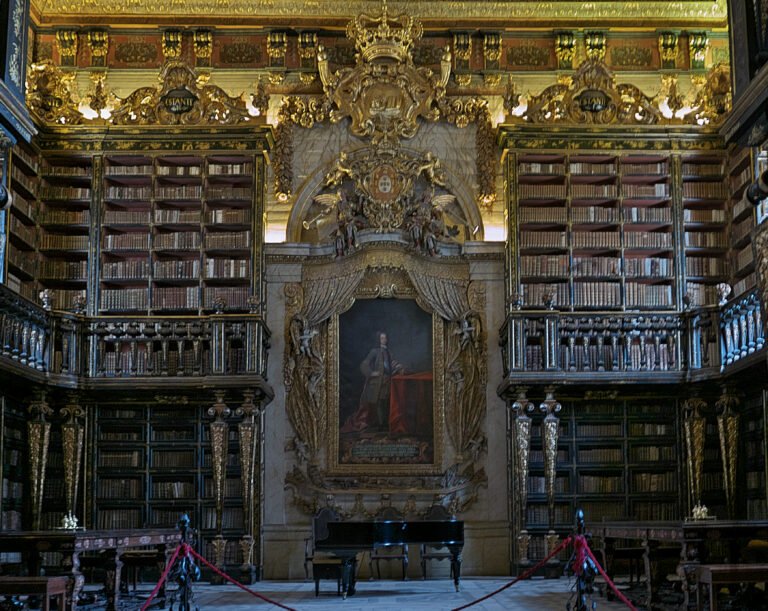 Estantes de livros e talha dourada no interior da Biblioteca Joanina, em Coimbra