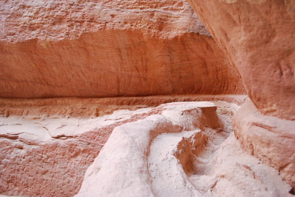 Canal escavado na rocha avermelhada do Siq, em Petra, fotografado em 2010.