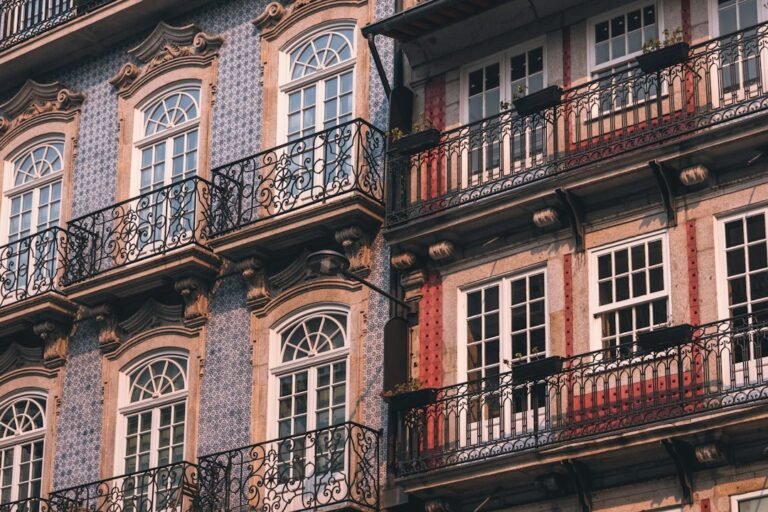 Fachadas históricas com azulejos, janelas e varandas de ferro no Porto