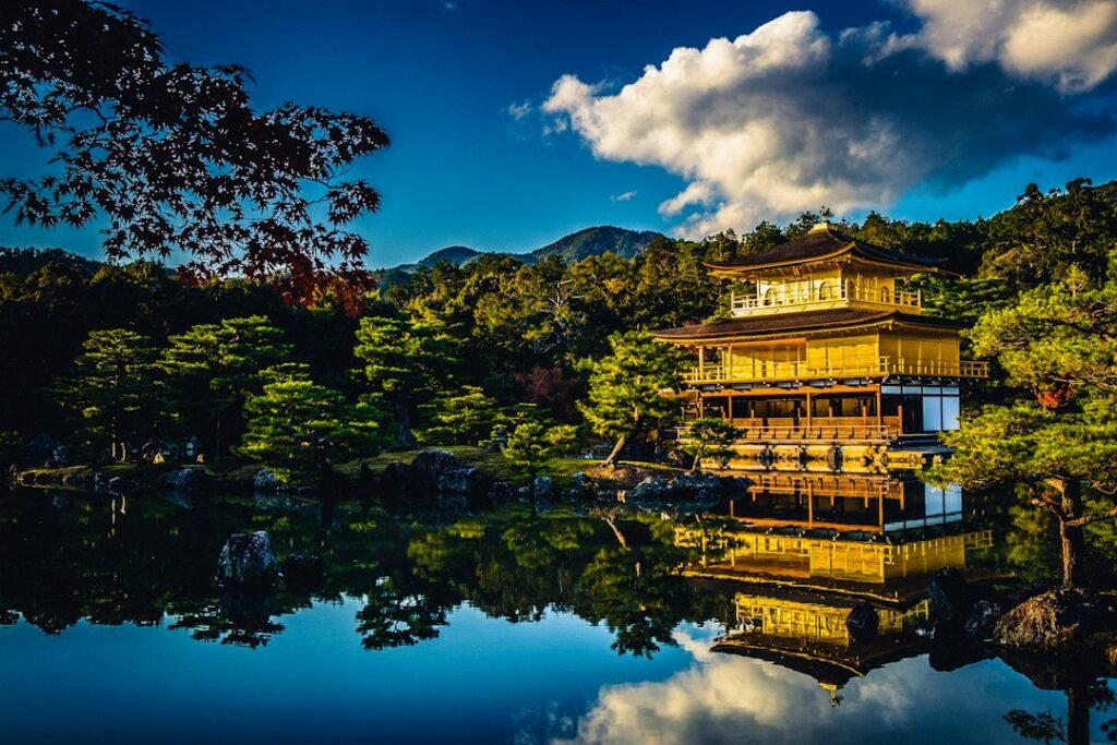 Pavilhão dourado diante de um lago, cercado por árvores em Kyoto, no Japão.