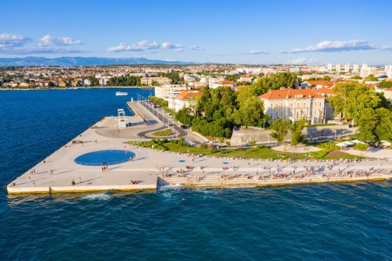 Vista aérea da orla de Zadar, com as escadarias do Órgão do Mar à direita e a instalação circular Saudação ao Sol à esquerda